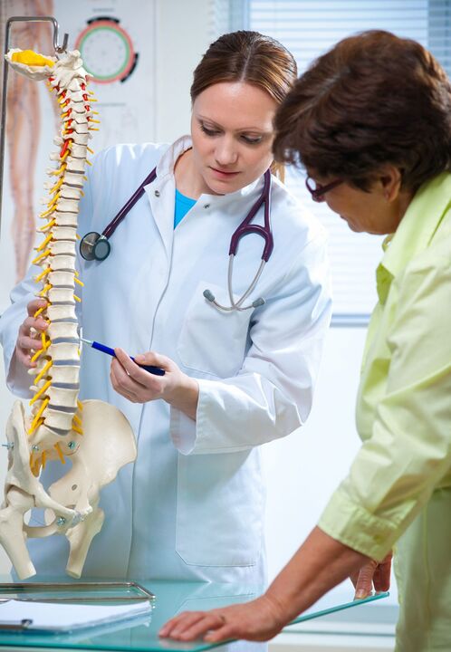 az orvos maketten mutatja be a gerinc osteochondrosisát